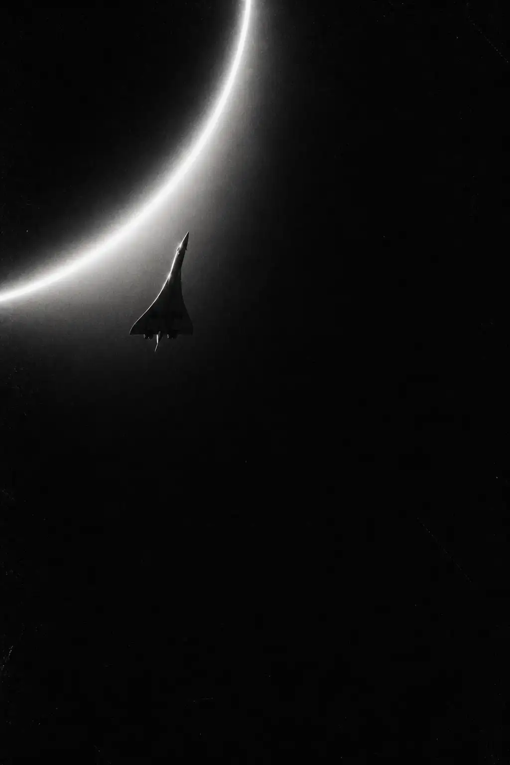 Concorde silhouetted beneath a bright celestial arc.